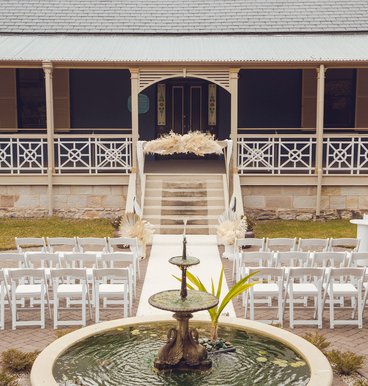 Newstead House Front Entrance set with white wedding chairs with fountain in the foreground